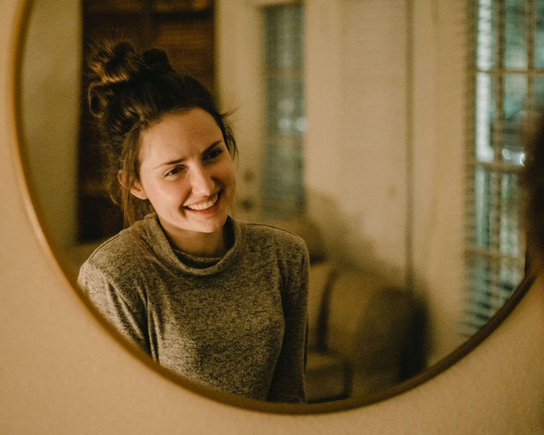 Person looking in mirror saying positive affirmations with confidence and joy